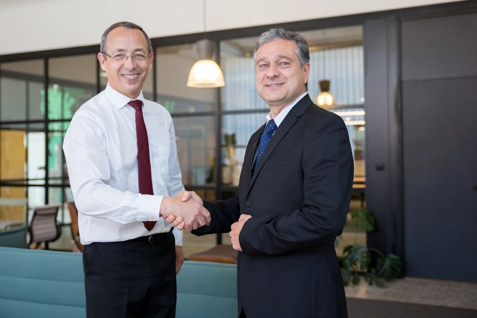 Consulente sorridente stringe la mano a un cliente soddisfatto.